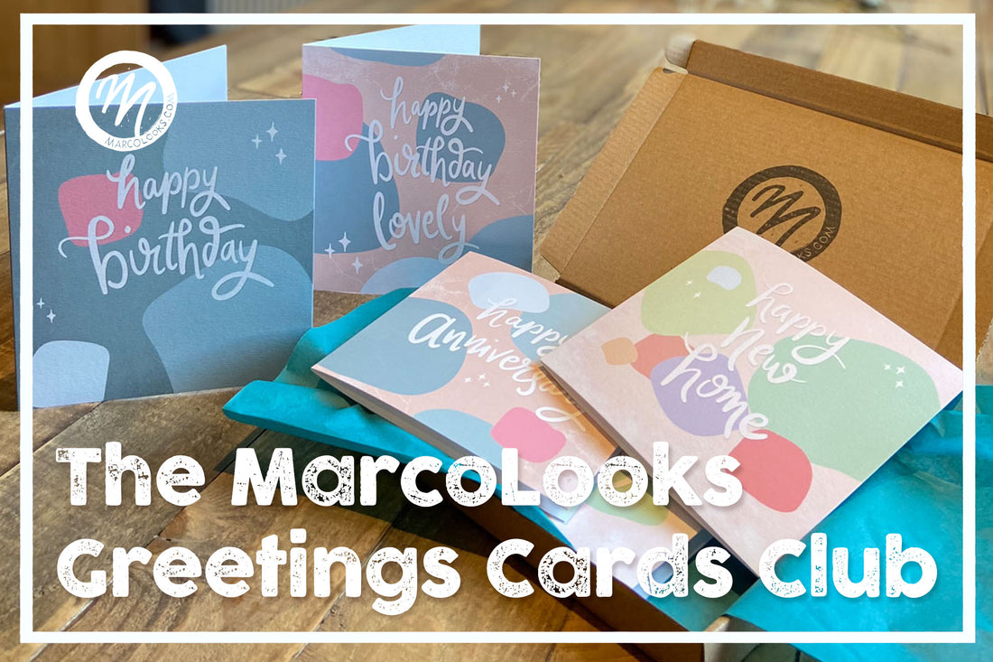 MarcoLooks Greetings Cards Club. Cards for any occasion sent straight to your home. Photo shows a selection of cards, on a beautiful wooden table. The cards sit in a small brown box with teal tissue paper